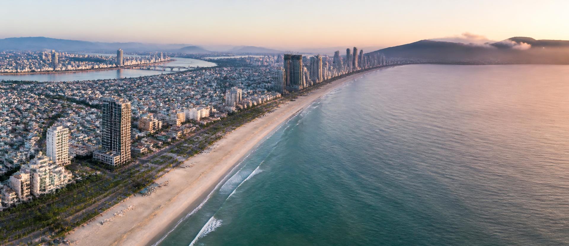 Aerial view of Da Nang's coastline at dawn with My Khe beach and the city skyline